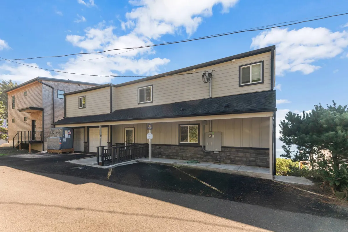 An exterior view showcasing the entrance ramp, front steps, and windows of the property. The scene exudes a welcoming mood, with natural light and a sense of community, and hints at gathering with friends or relaxing in a quiet outdoor setting.